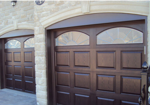 Two repaired wood-looking garage doors on a nice house in Peachtree City GA